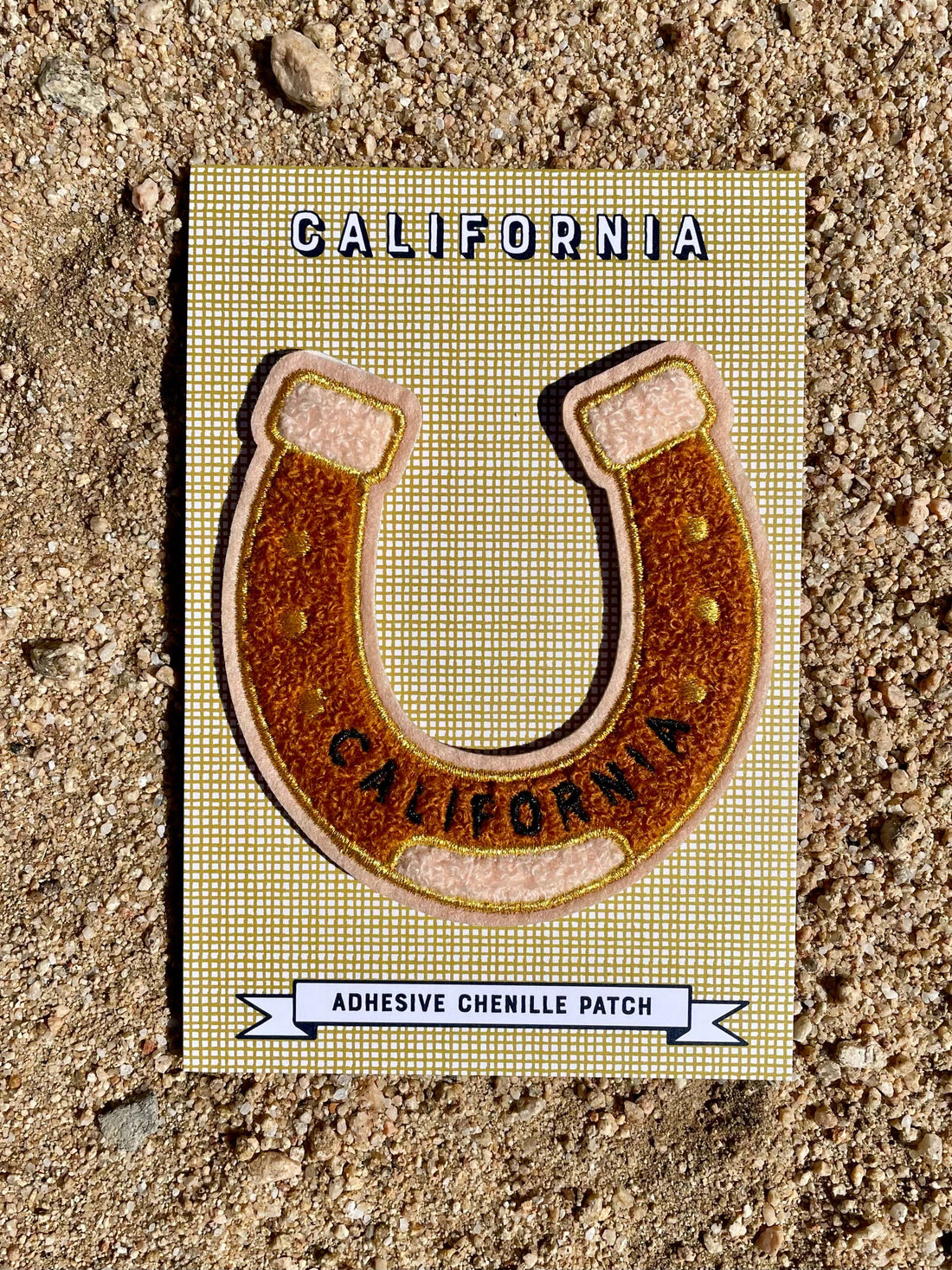 An adhesive chenille patch designed as a horseshoe with 'California' text, placed on a card with the same design.