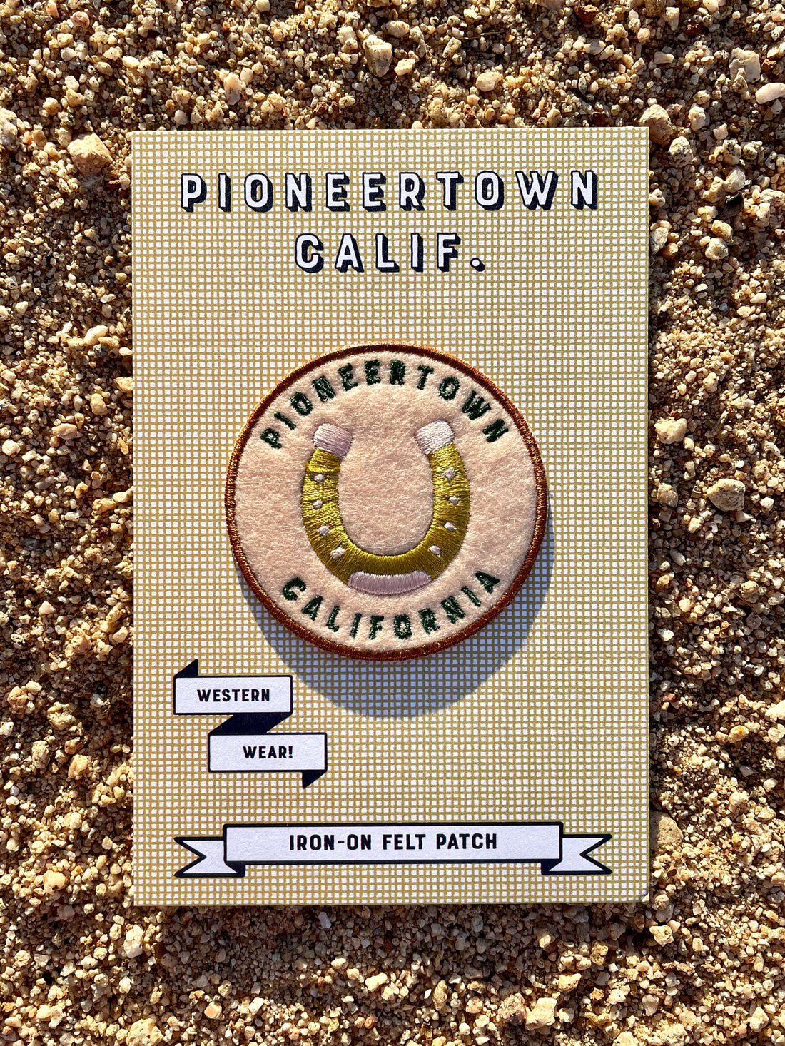 A round felted patch picturing a horseshoe and the text 'Pioneertown California'.