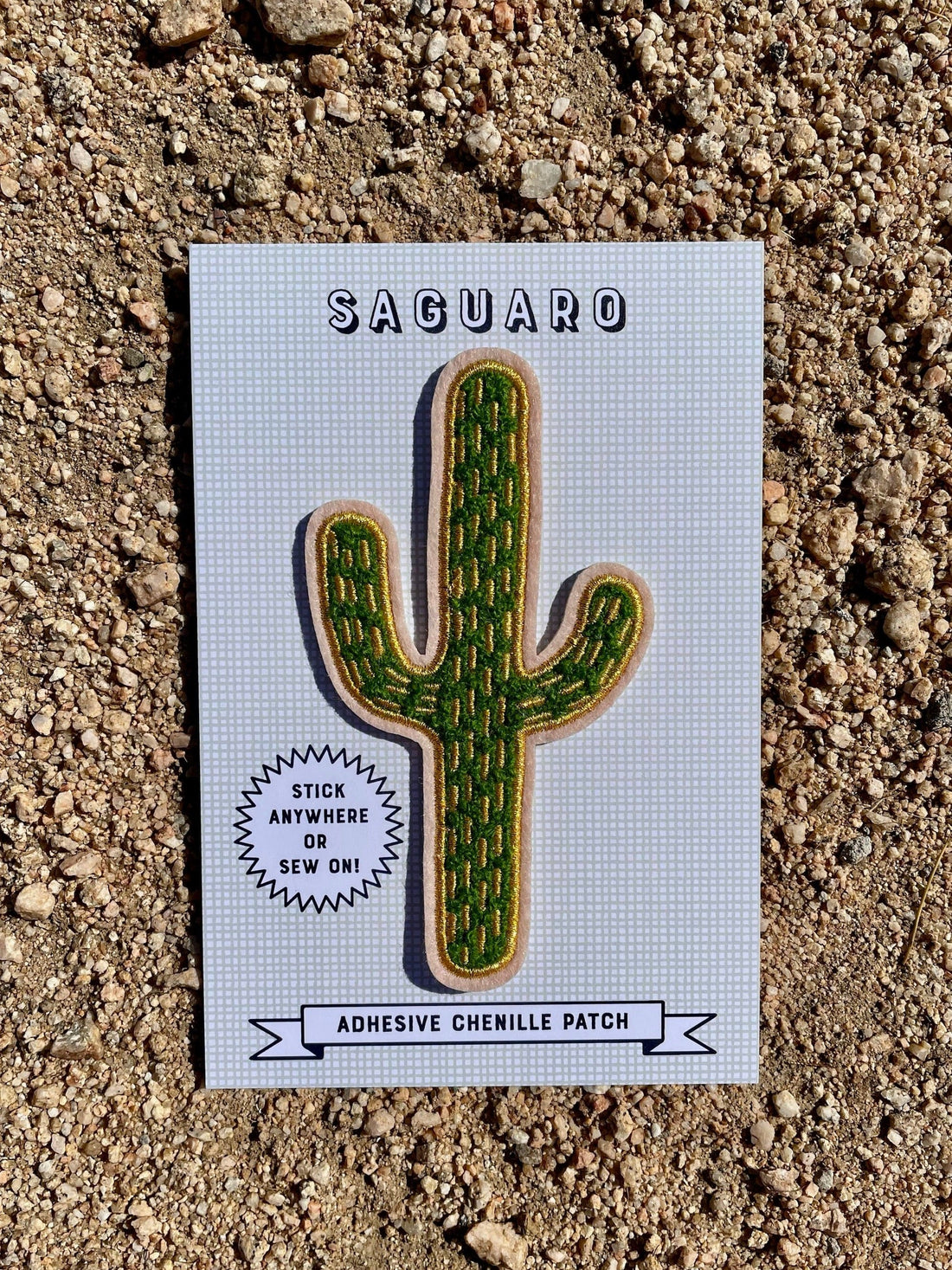 A felt patch in the shape of a saguaro. It is green with gold details.