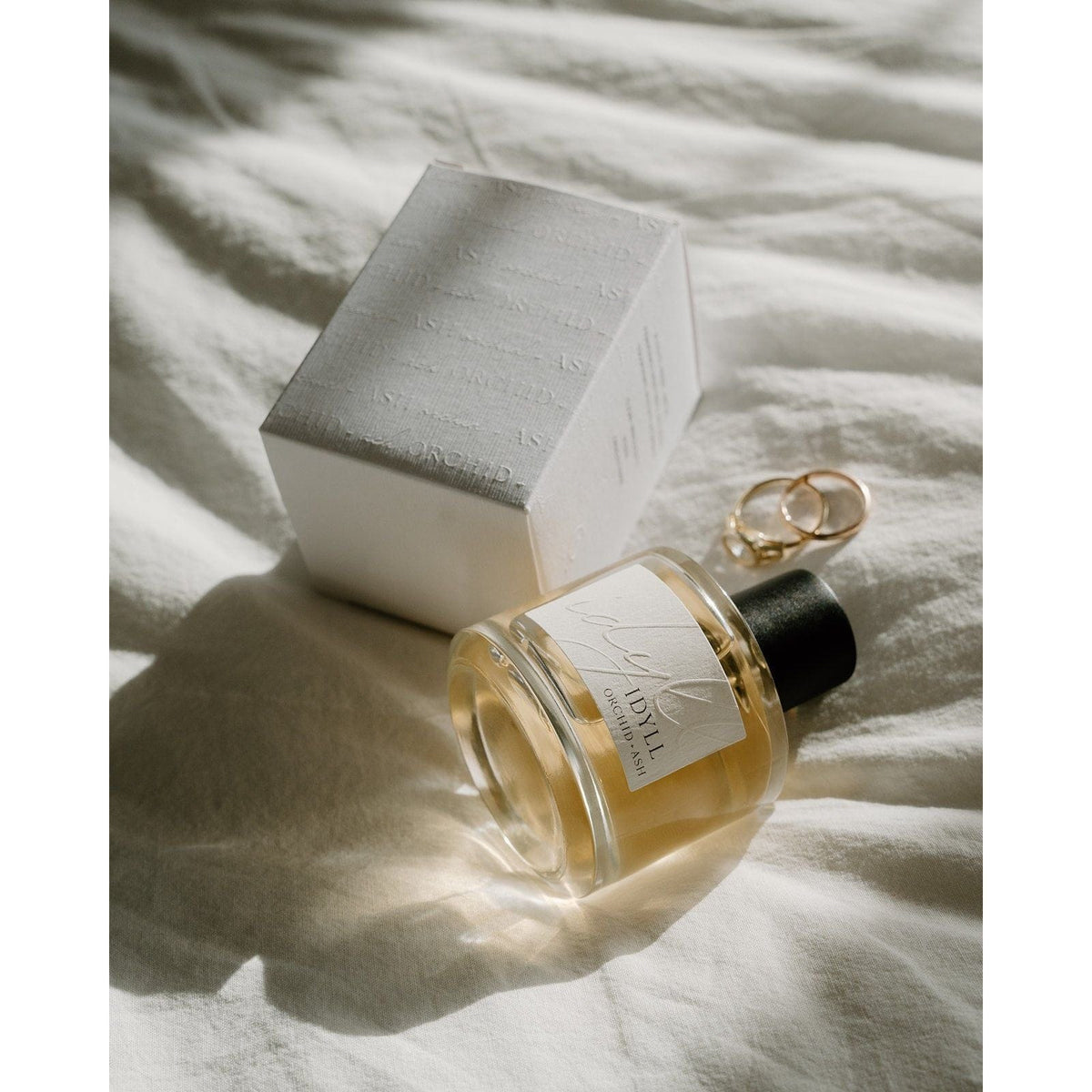 Perfume bottle with a box on a textured surface